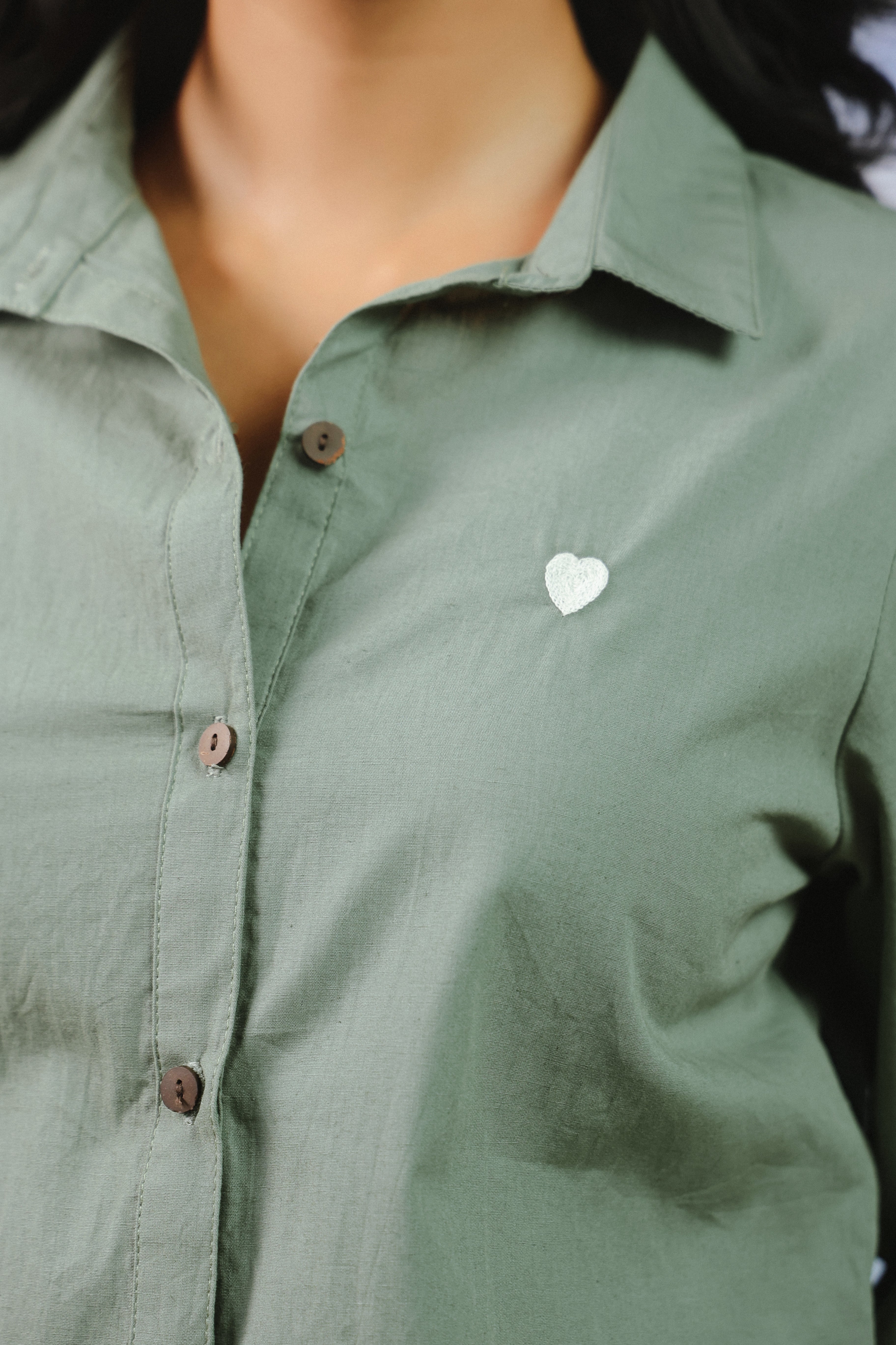 Woman wearing a sage green cotton shirt and shorts co-ord set featuring a classic button-down collared shirt with full sleeves and matching relaxed-fit shorts, ideal for casual outings, vacations, resort wear, and everyday summer styling.