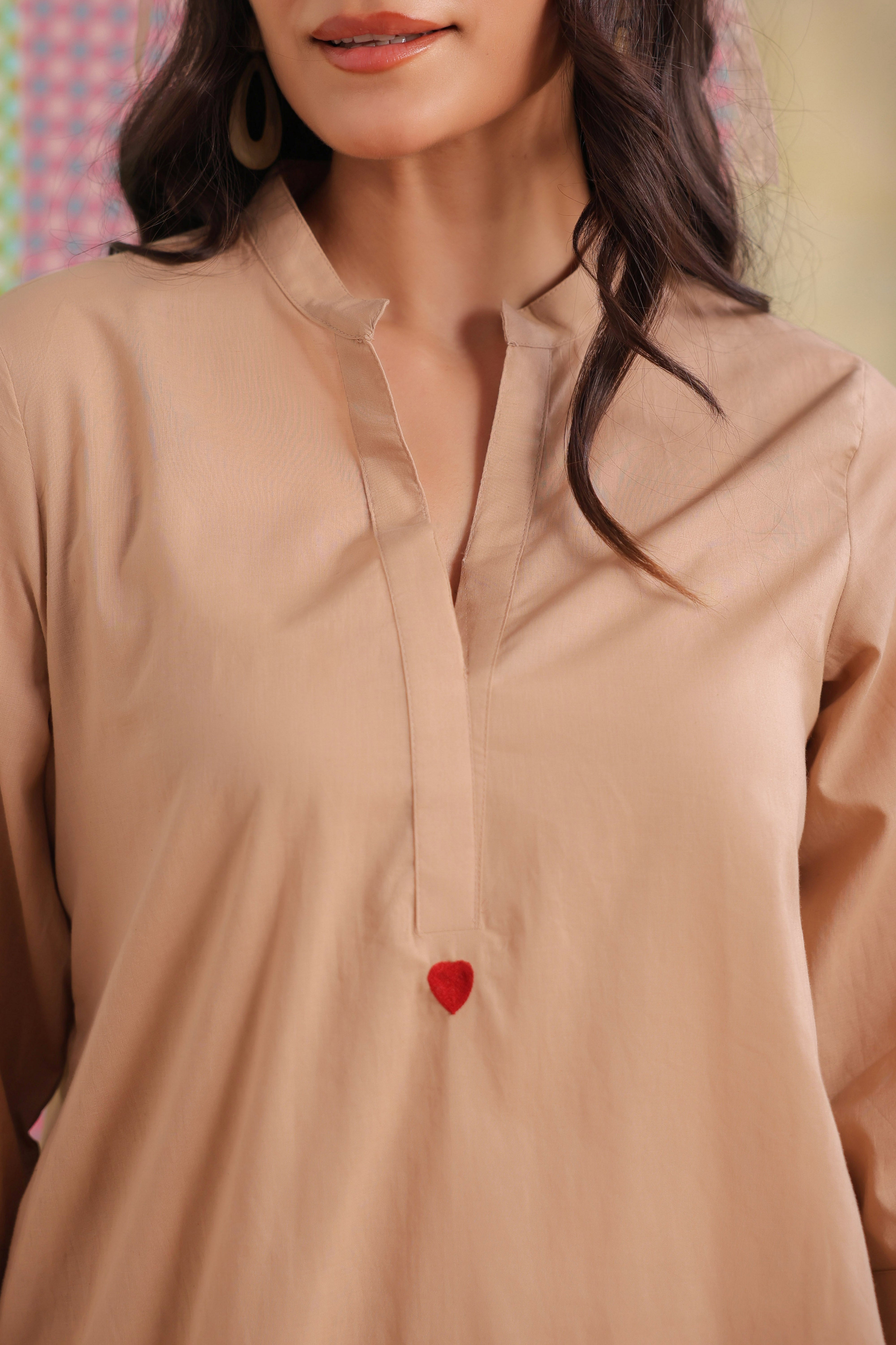 Woman wearing a beige cotton co-ord set featuring a relaxed-fit straight kurta with a mandarin V-neck and matching elasticated jogger pants, offering a minimalist and elegant look for casual, office, travel, and everyday wear.