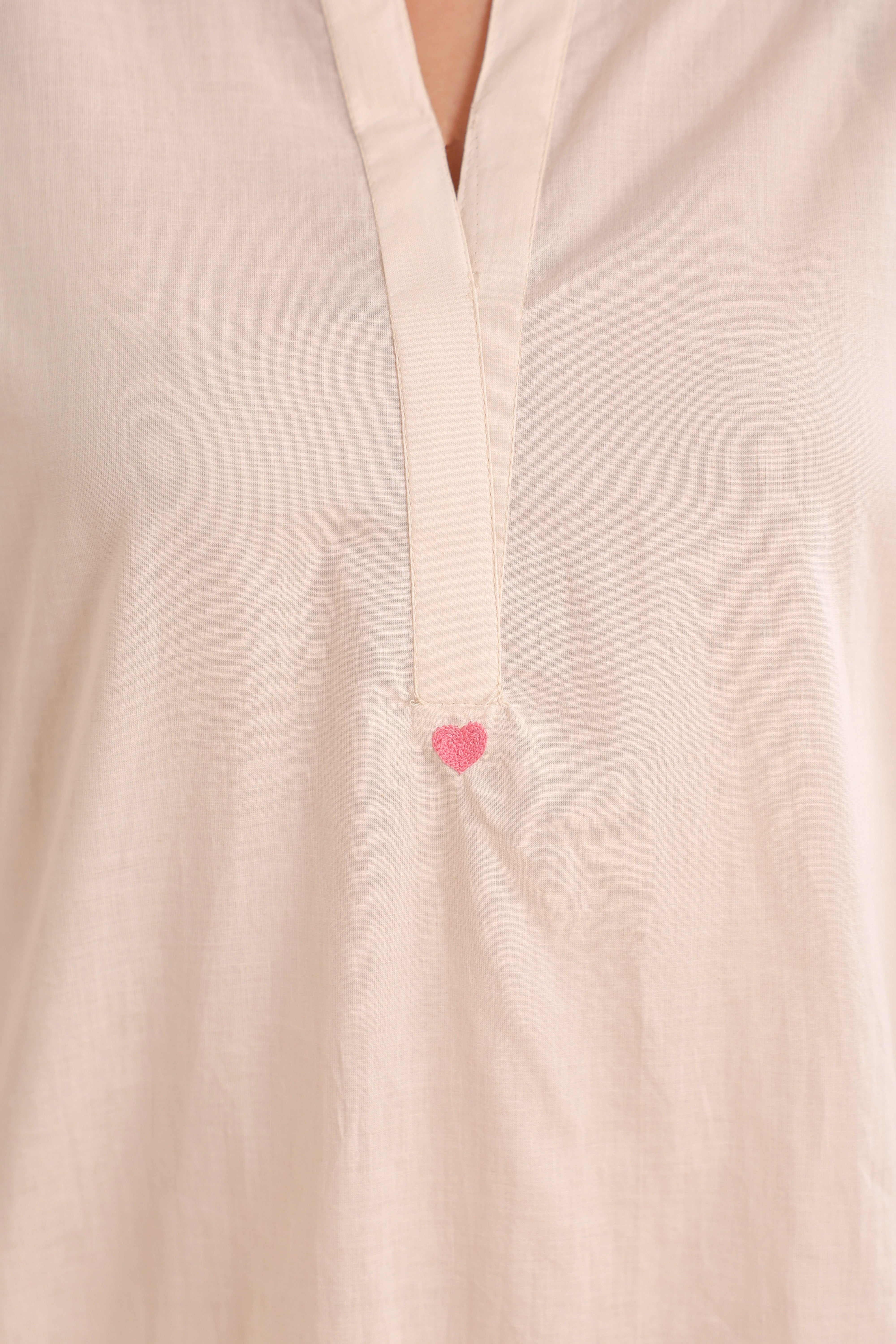 Woman wearing an ivory cotton co-ord set featuring a relaxed-fit straight kurta with a mandarin V-neck and matching elasticated jogger pants, offering a minimalist and elegant look for casual, office, and everyday wear.