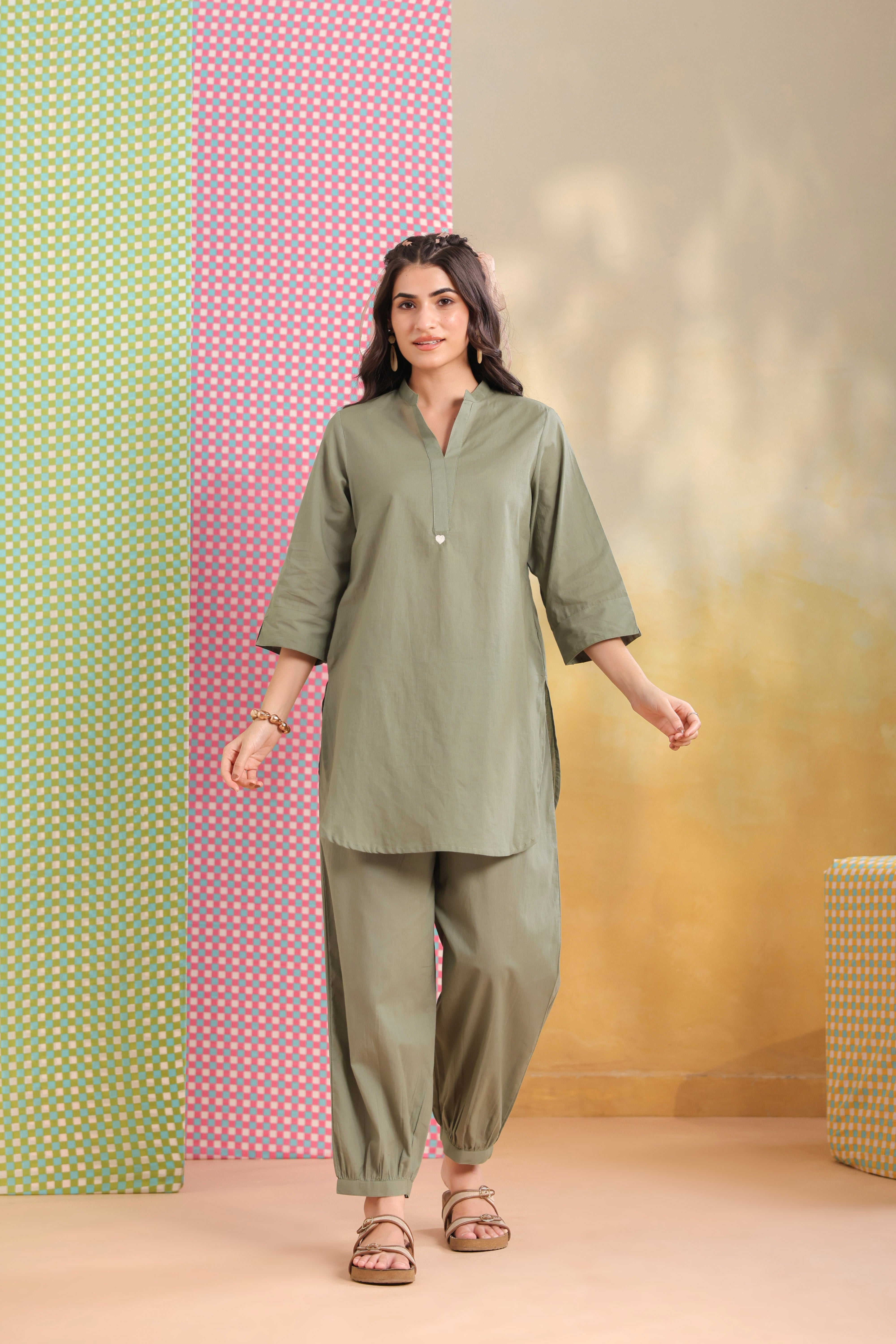 Woman wearing a sage green cotton co-ord set featuring a relaxed-fit straight kurta with a mandarin V-neck and matching elasticated jogger pants, ideal for casual, office, and everyday wear.