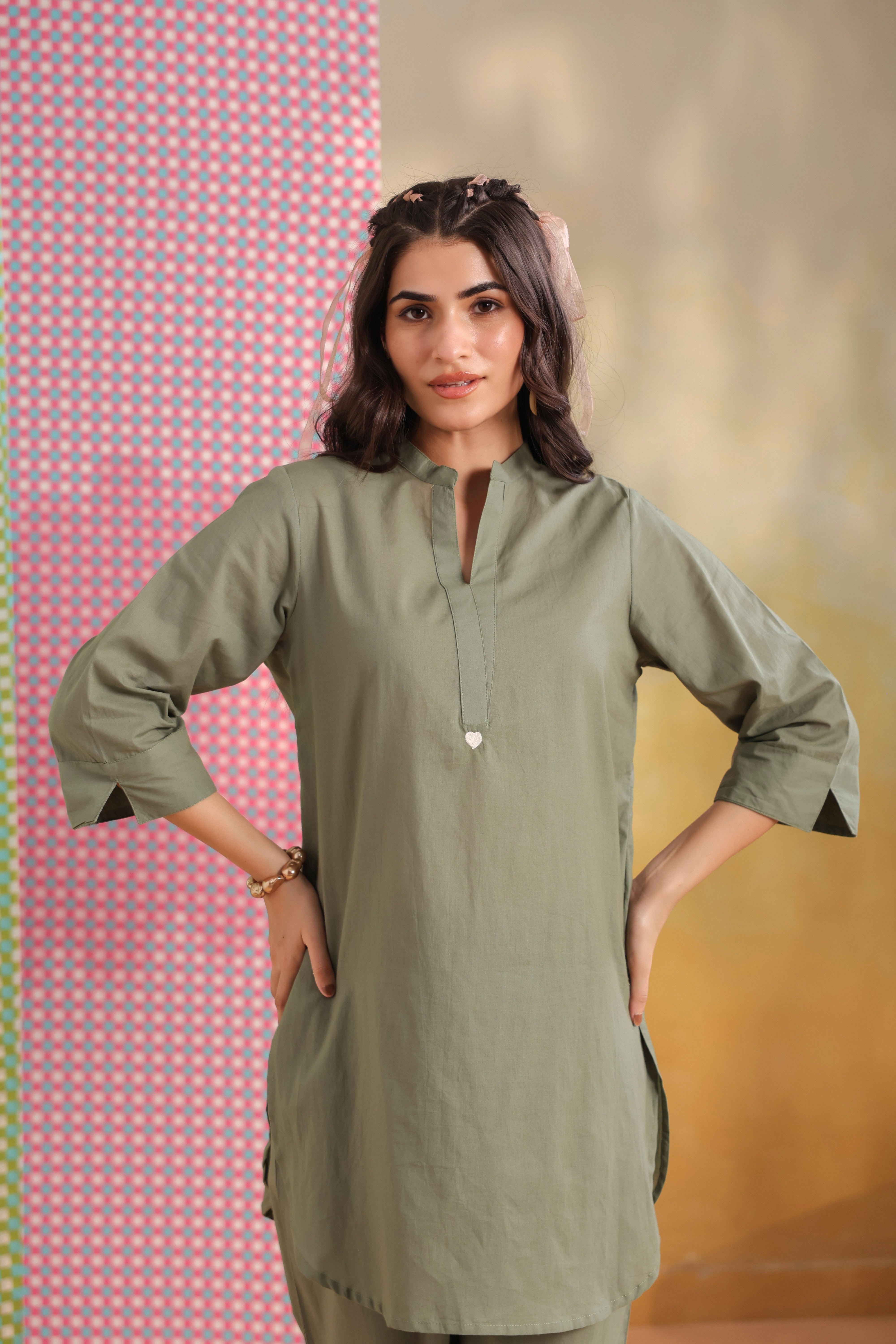 Woman wearing a sage green cotton co-ord set featuring a relaxed-fit straight kurta with a mandarin V-neck and matching elasticated jogger pants, ideal for casual, office, and everyday wear.