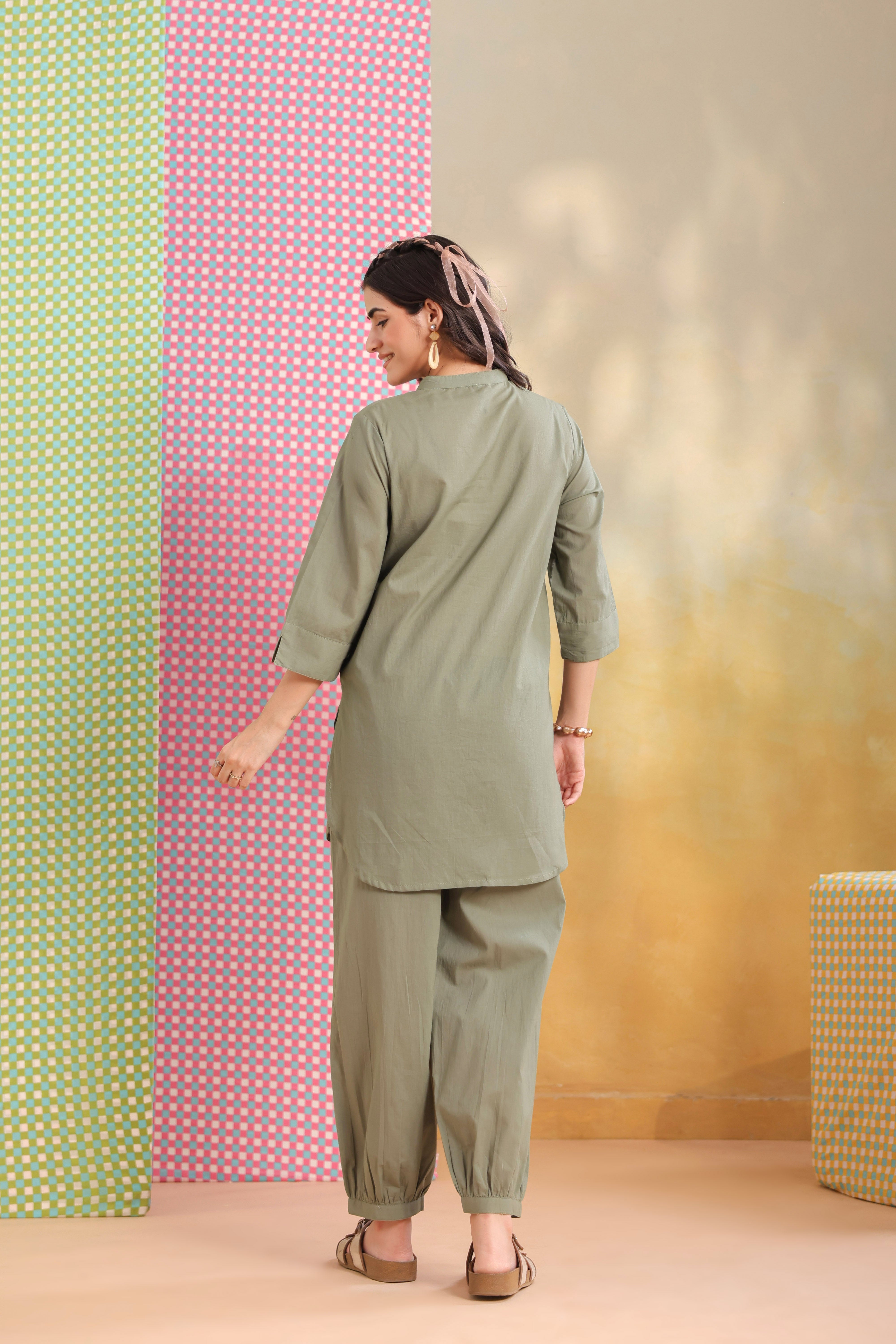 Woman wearing a sage green cotton co-ord set featuring a relaxed-fit straight kurta with a mandarin V-neck and matching elasticated jogger pants, ideal for casual, office, and everyday wear.