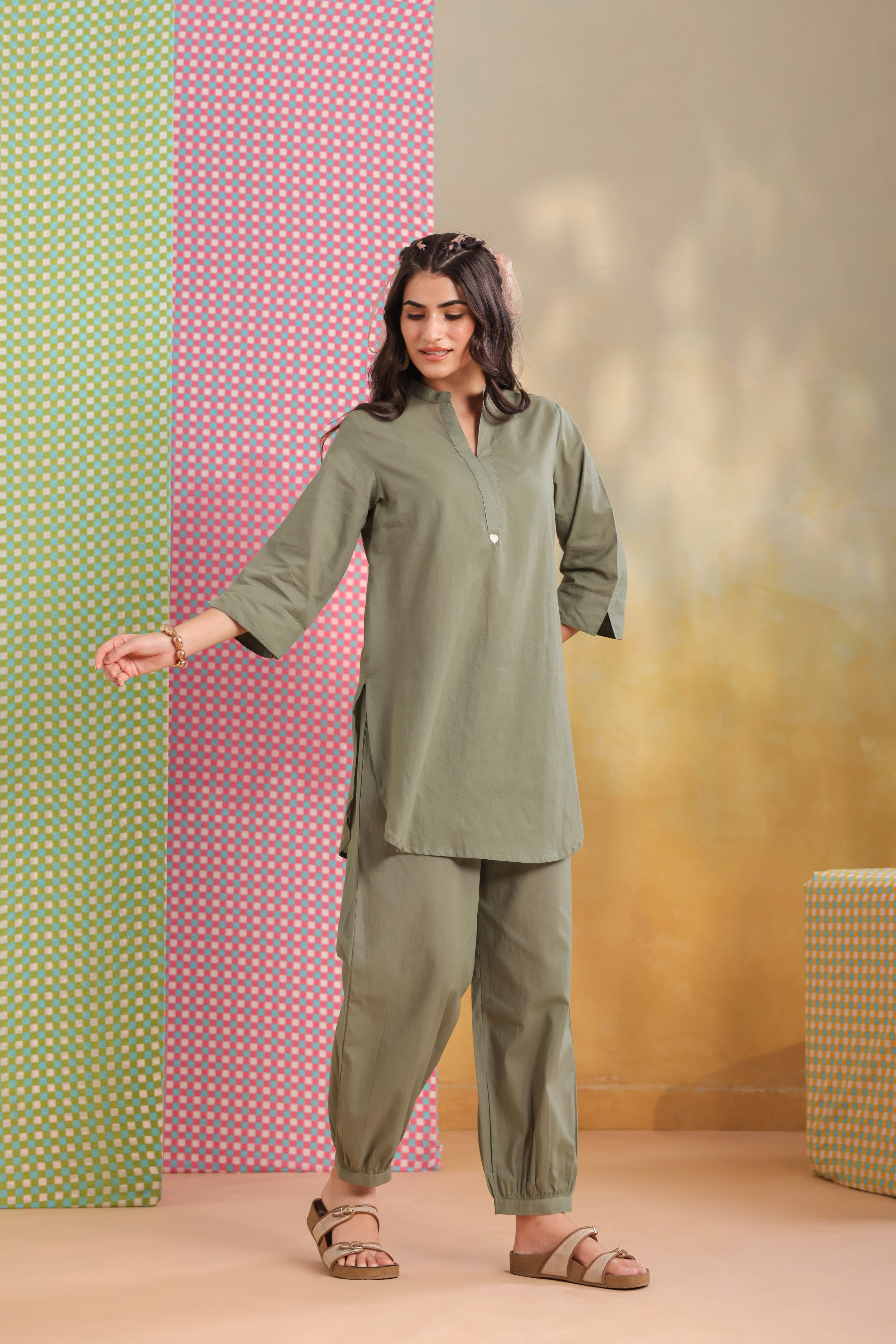 Woman wearing a sage green cotton co-ord set featuring a relaxed-fit straight kurta with a mandarin V-neck and matching elasticated jogger pants, ideal for casual, office, and everyday wear.