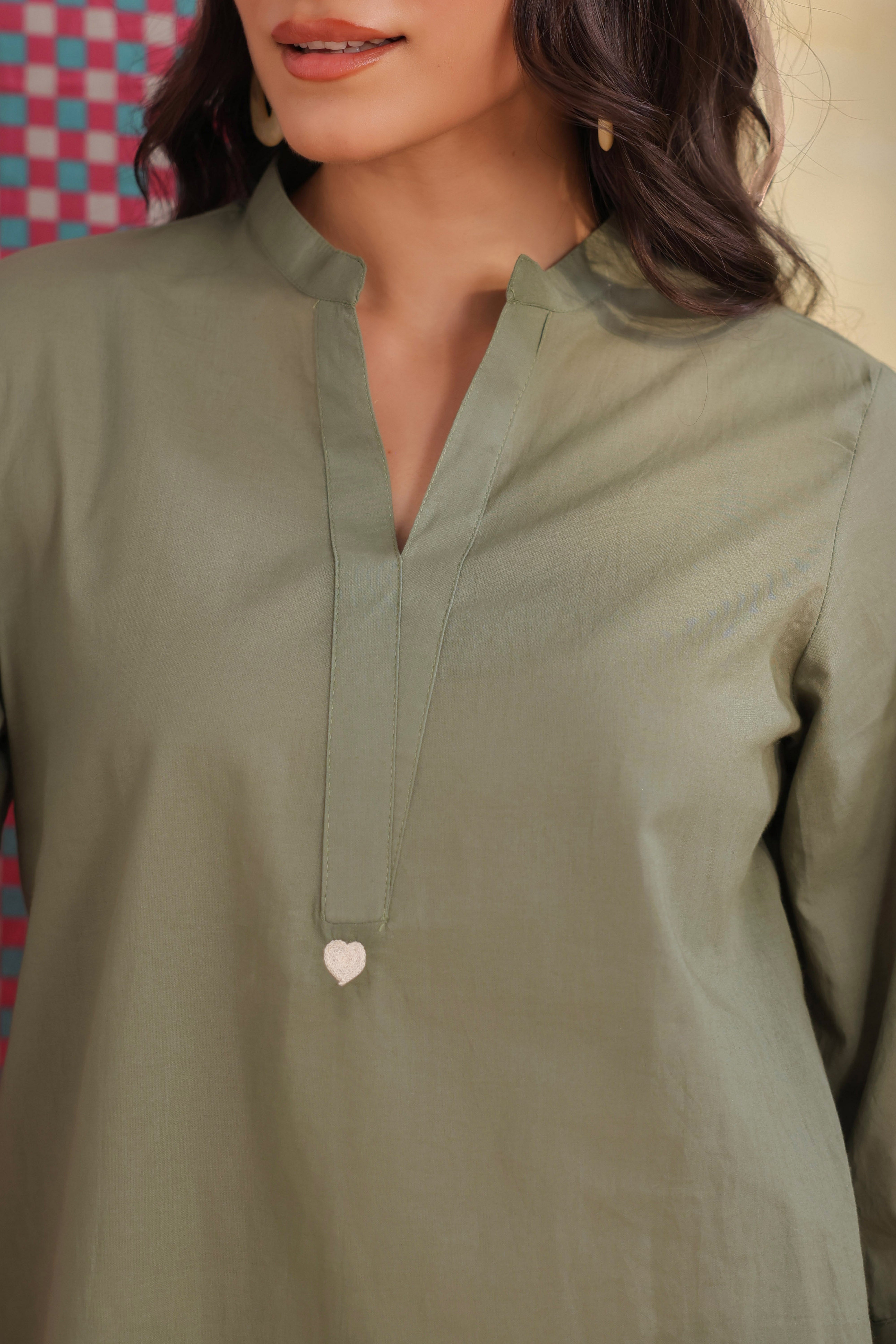 Woman wearing a sage green cotton co-ord set featuring a relaxed-fit straight kurta with a mandarin V-neck and matching elasticated jogger pants, ideal for casual, office, and everyday wear.