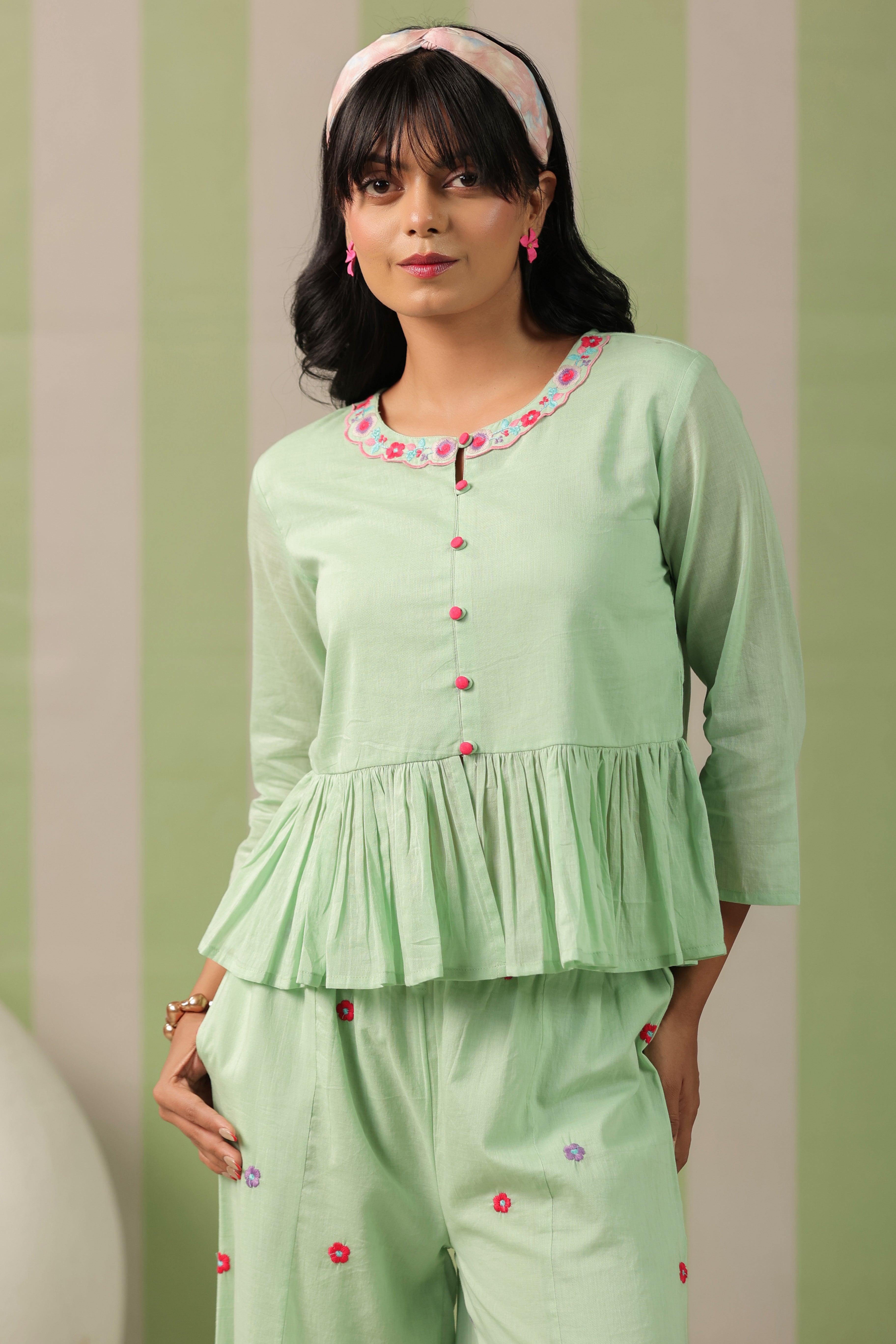 Woman wearing a pista green embroidered peplum co-ord set with wide-leg palazzo pants, round embroidered neckline, and floral detailing for ethnic casual wear