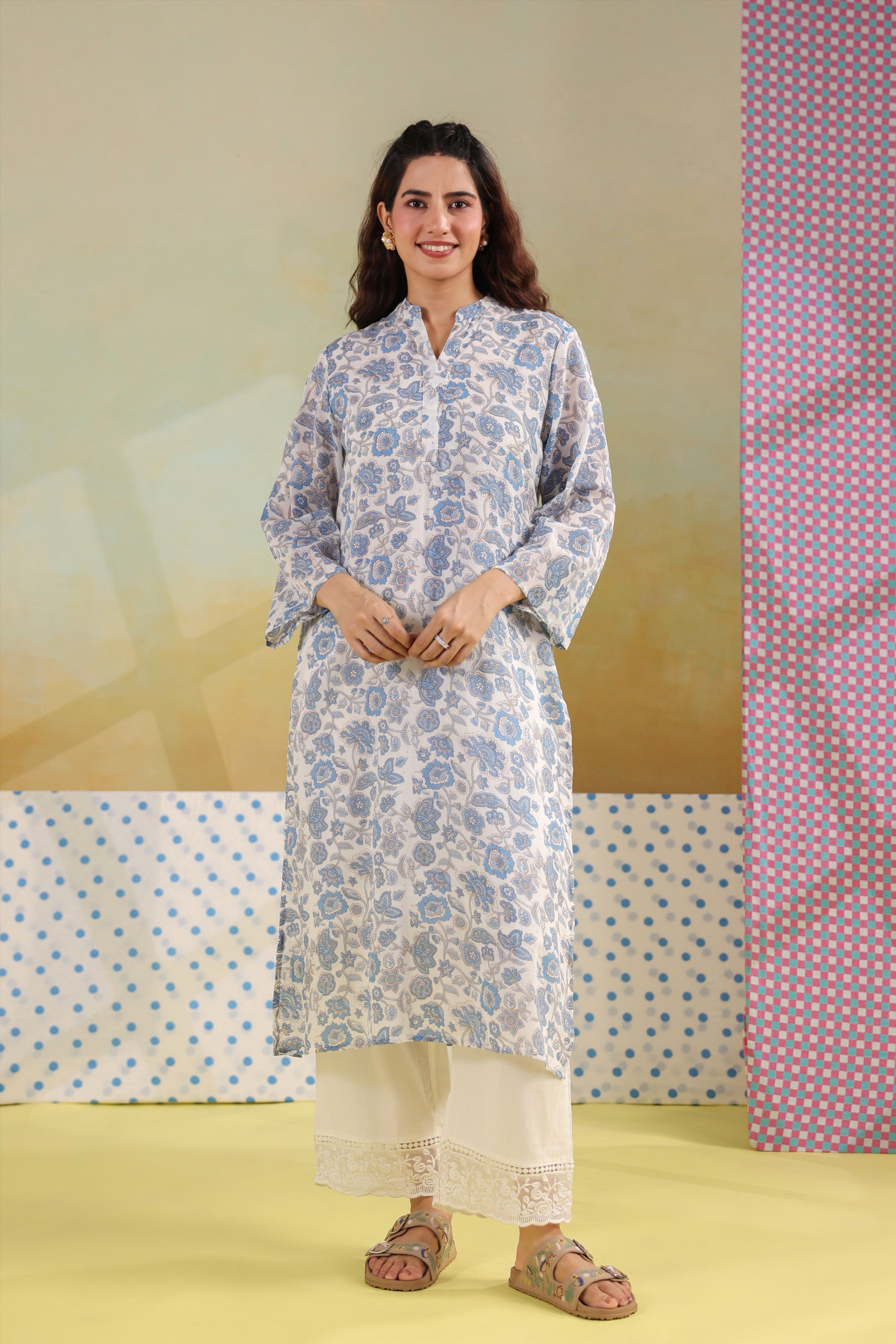 Woman wearing a blue floral printed cotton straight kurta paired with a white lace palazzo, styled for casual and office ethnic wear.
