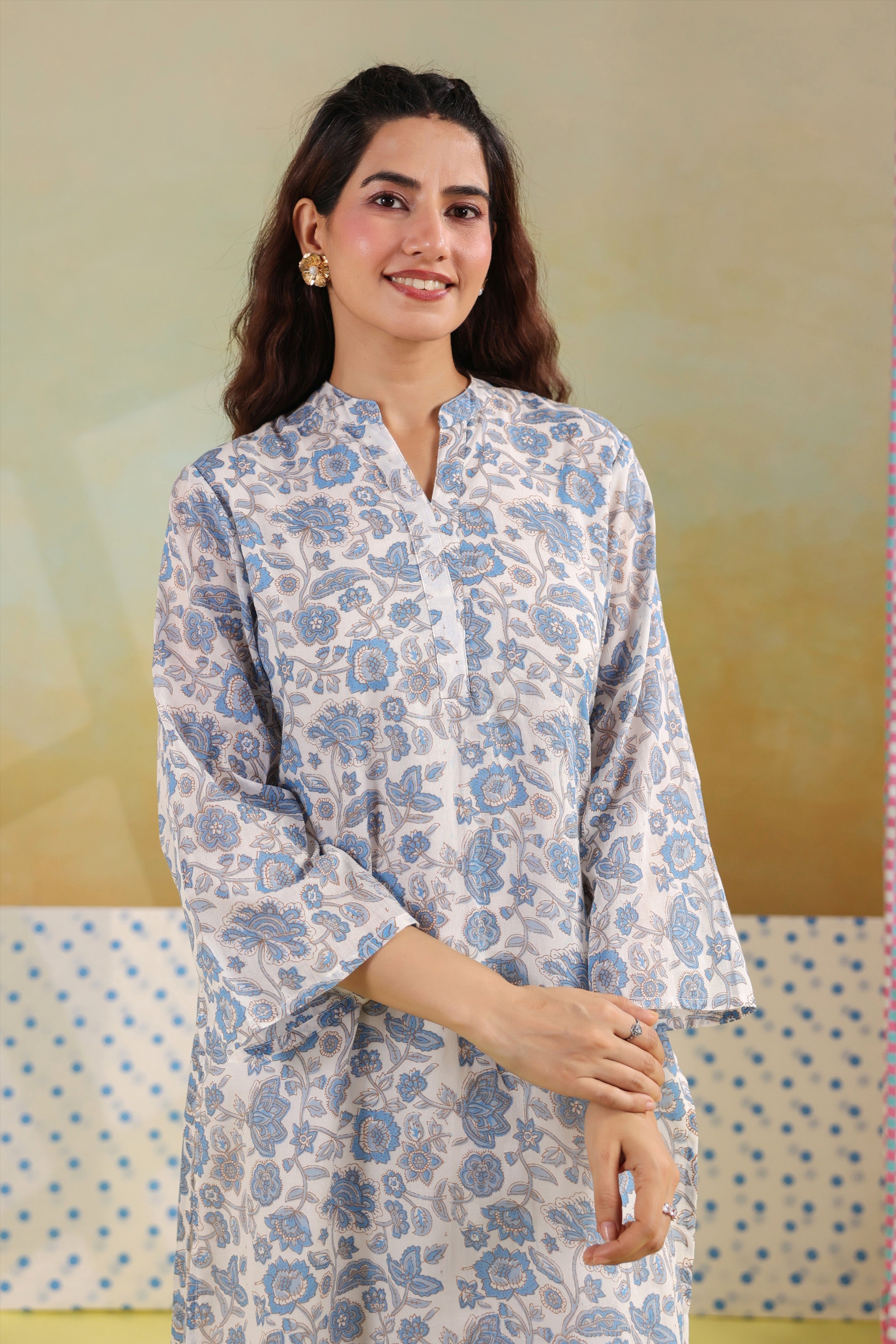 Woman wearing a blue floral printed cotton straight kurta paired with a white lace palazzo, styled for casual and office ethnic wear.