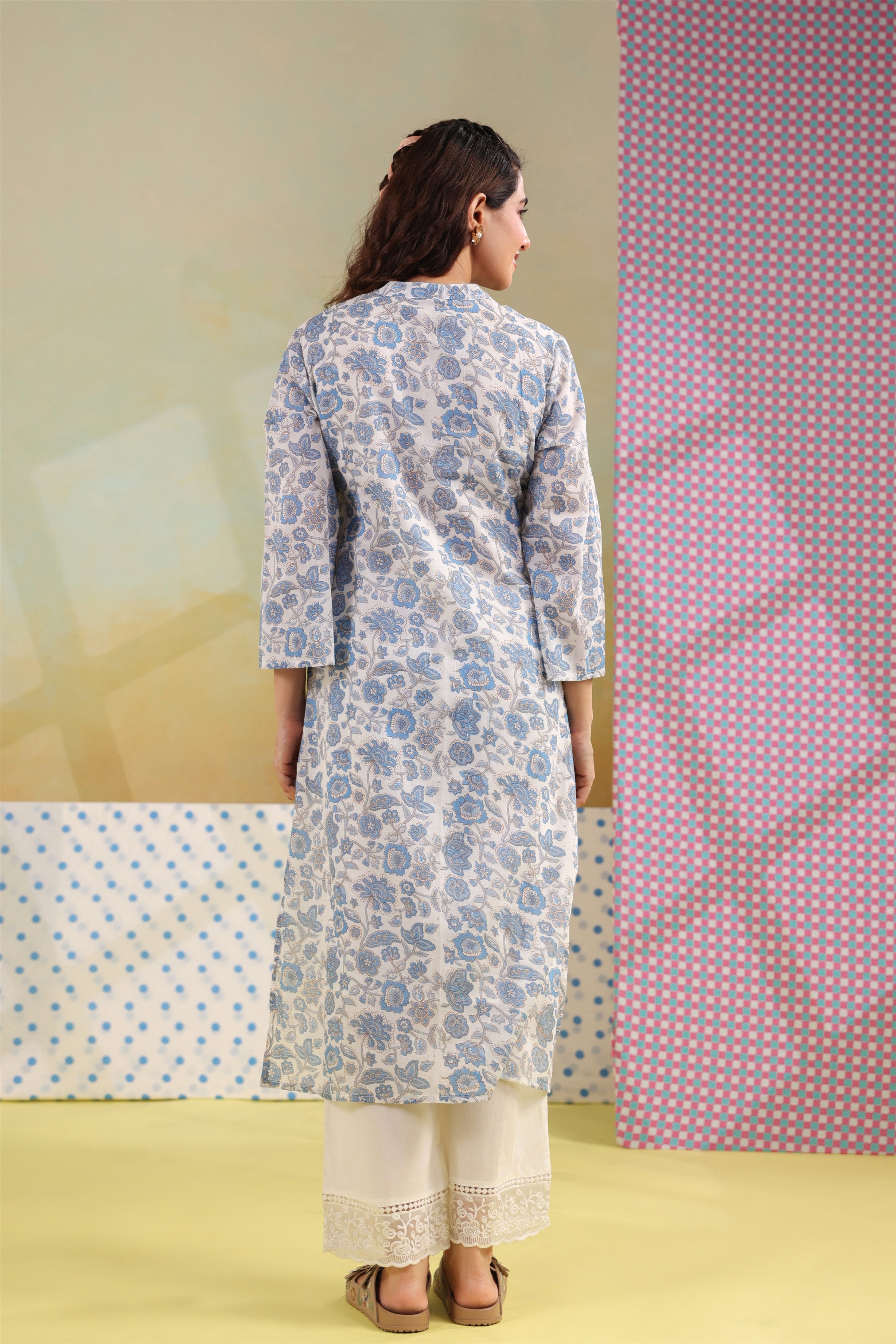Woman wearing a blue floral printed cotton straight kurta paired with a white lace palazzo, styled for casual and office ethnic wear.