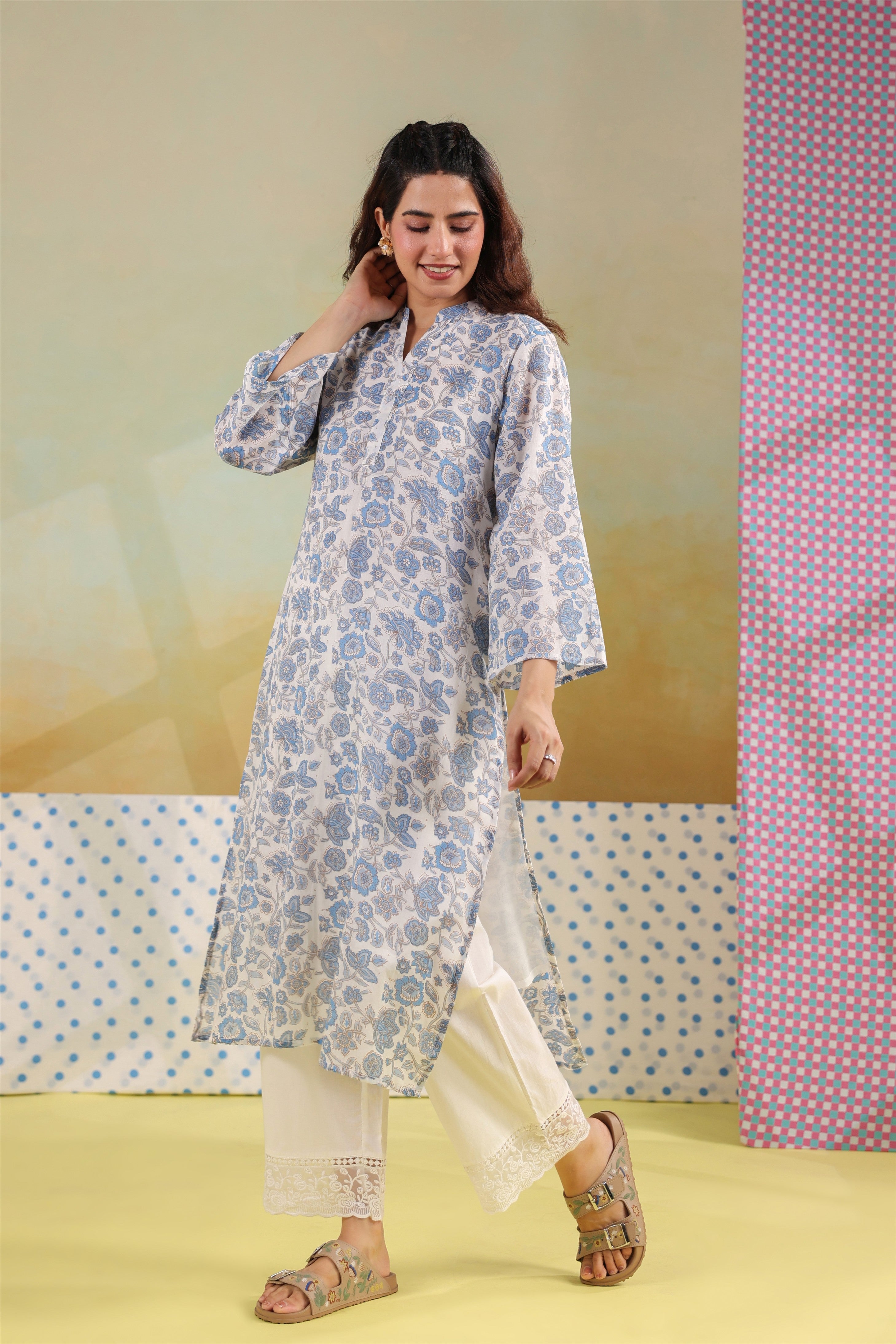 Woman wearing a blue floral printed cotton straight kurta paired with a white lace palazzo, styled for casual and office ethnic wear.