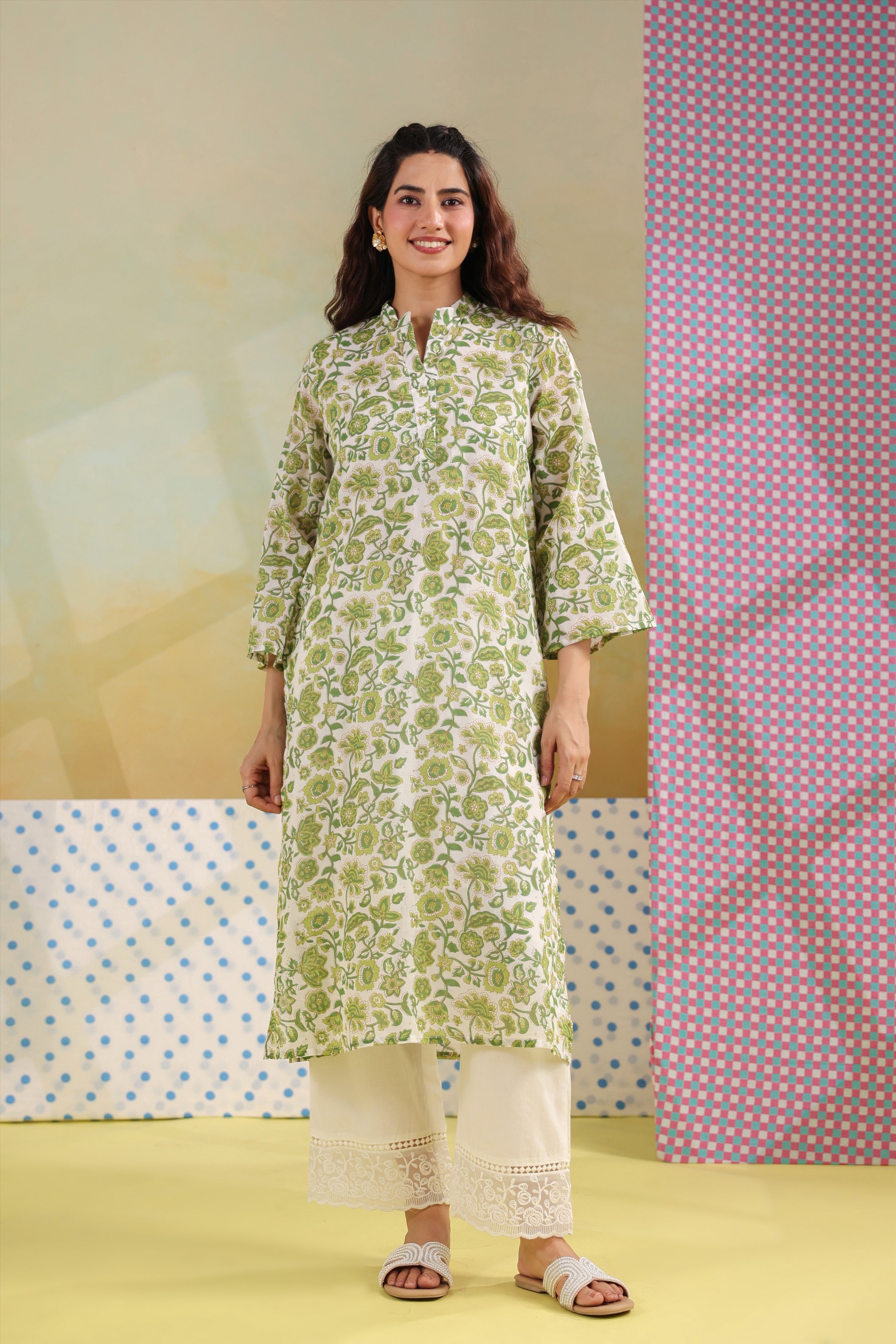 Woman wearing a green floral printed cotton straight kurta paired with a white lace palazzo, styled for casual and office ethnic wear.