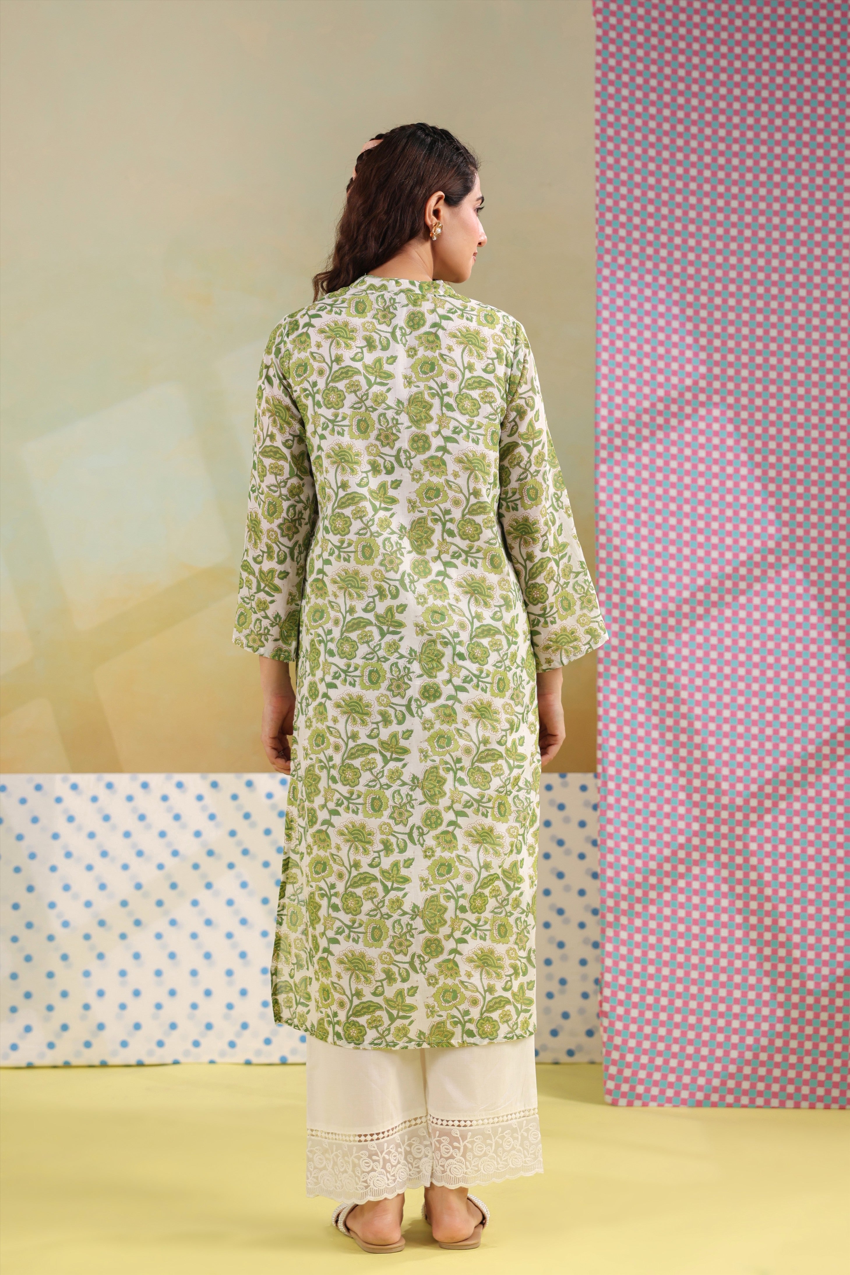Woman wearing a green floral printed cotton straight kurta paired with a white lace palazzo, styled for casual and office ethnic wear.