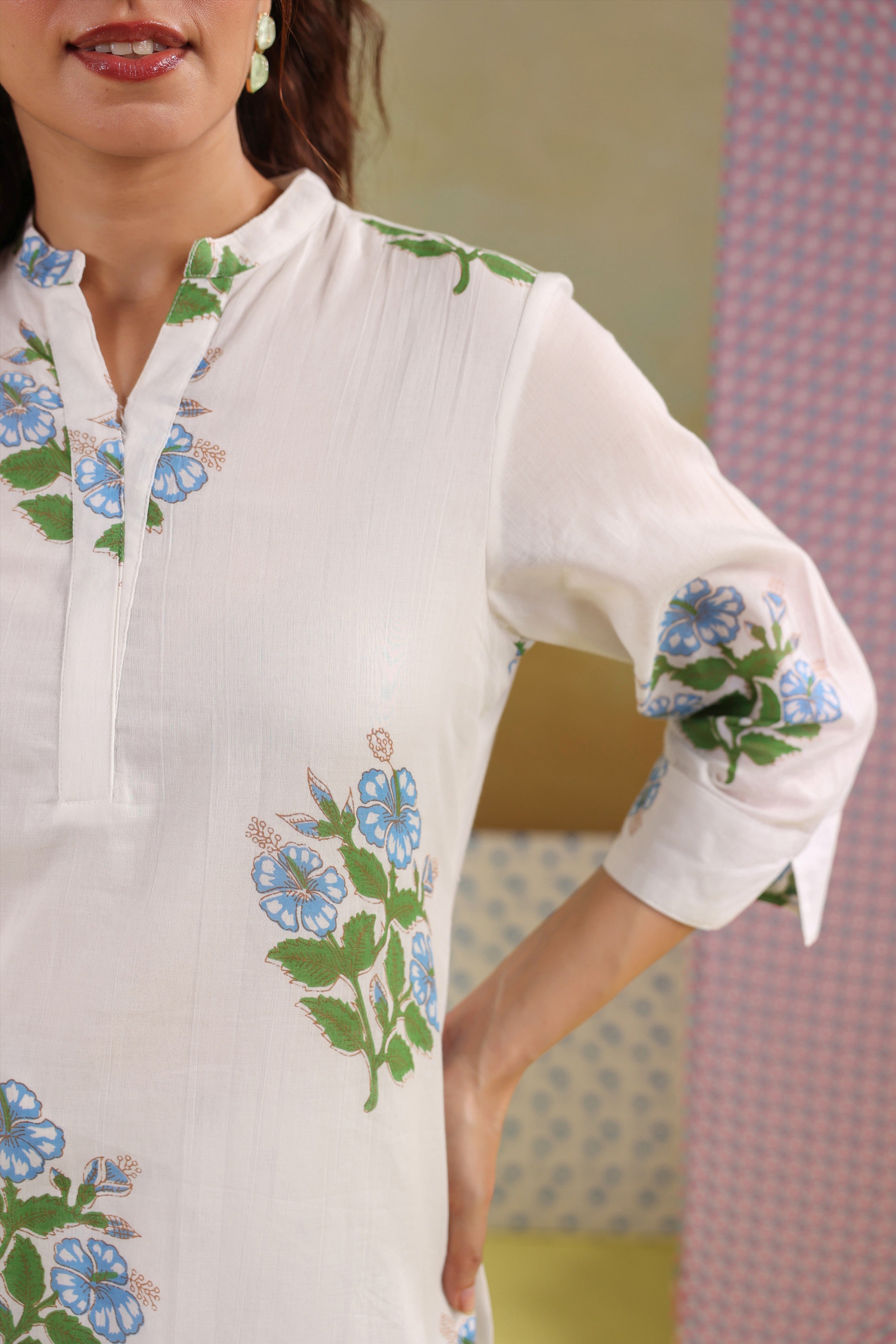 Woman wearing a white cotton floral printed co-ord set featuring a Mandarin collar top and blue polka dot balloon pants, ideal for casual, office, and summer wear.