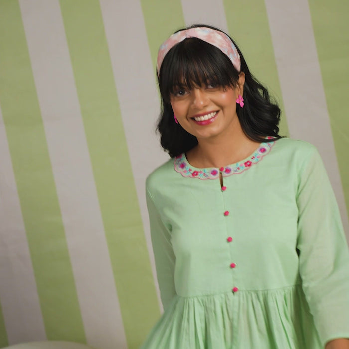 Woman wearing a pista green embroidered peplum co-ord set with wide-leg palazzo pants, round embroidered neckline, and floral detailing for ethnic casual wear
