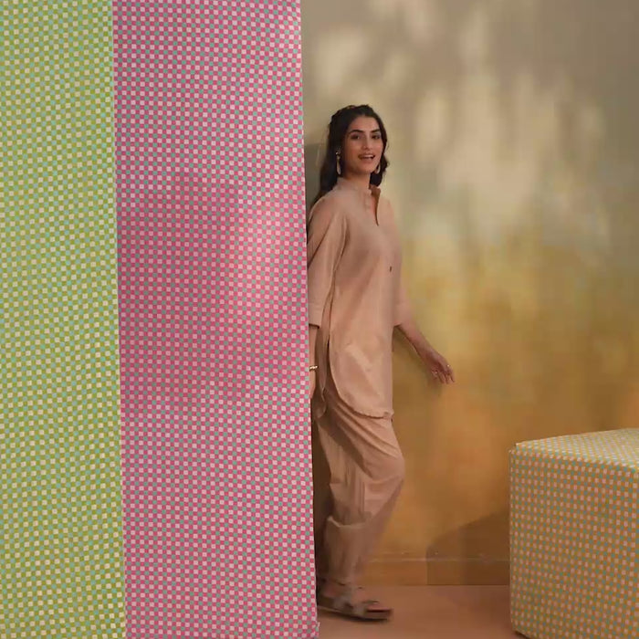Woman wearing a beige cotton co-ord set featuring a relaxed-fit straight kurta with a mandarin V-neck and matching elasticated jogger pants, offering a minimalist and elegant look for casual, office, travel, and everyday wear.